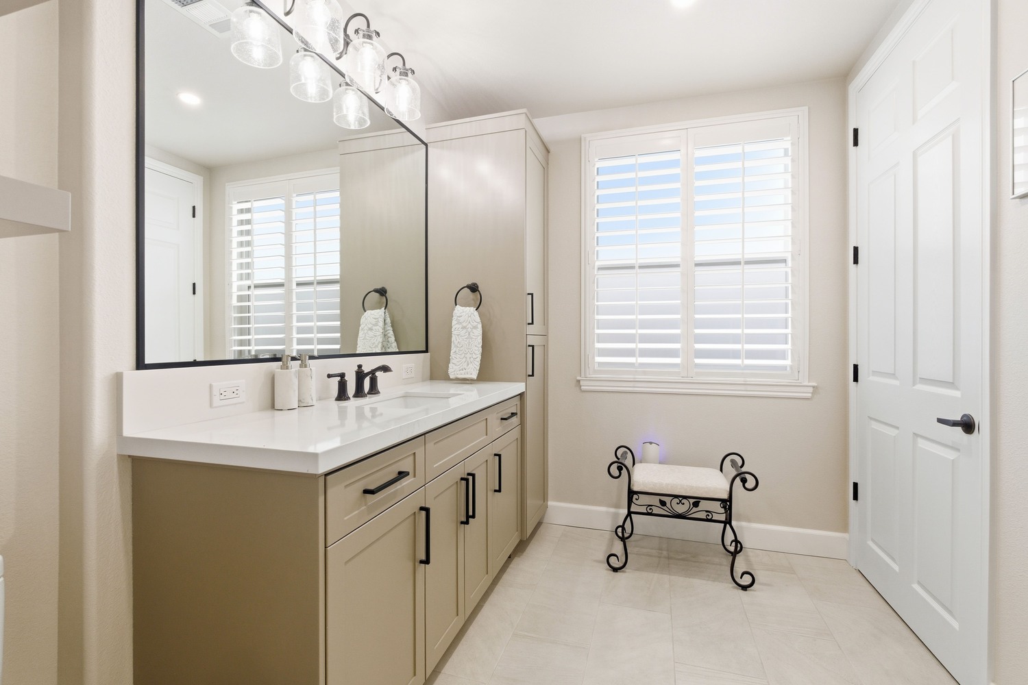 Modern Fresno CA bathroom with double vanity, large mirror, and neutral cabinetry