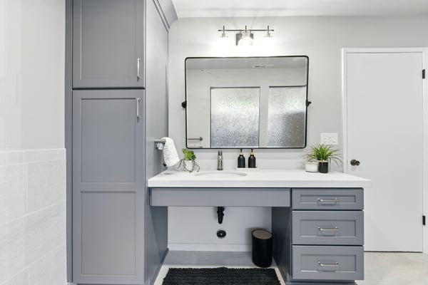 Accessible bathroom vanity with gray cabinets and large mirror in Fresno