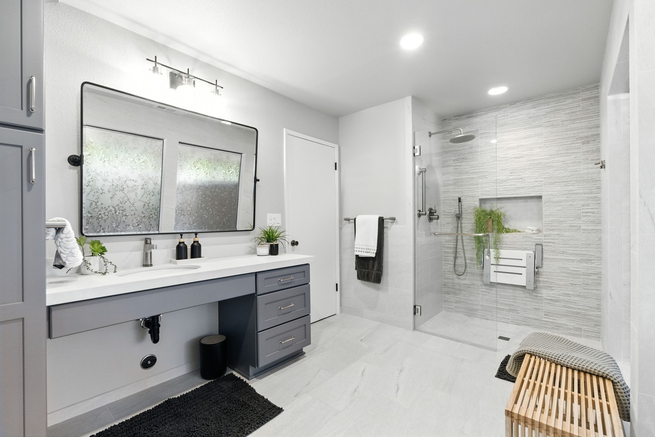 Modern Fresno bathroom with large vanity, gray cabinets, walk in shower, and frosted floral mirrors