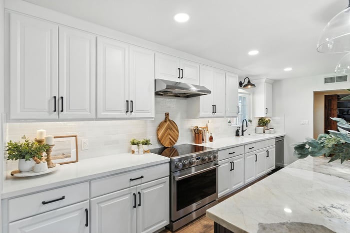 Stylish kitchen with stainless steel appliances, white cabinetry, and marble island countertop in Clovis, CA