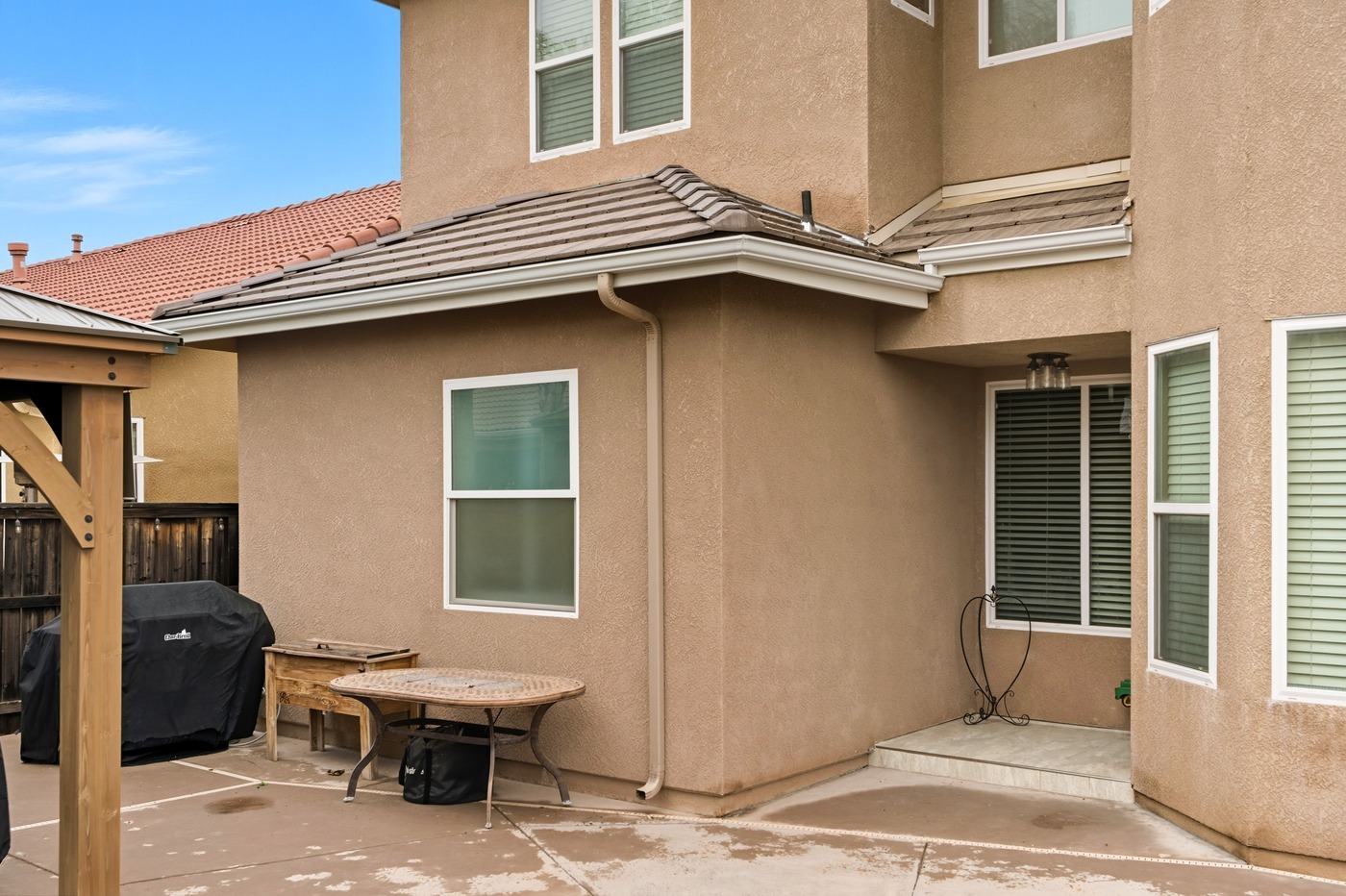 Backyard view of a Fresno home with tan stucco exterior and patio space Backyard view of a Fresno home with tan stucco exterior and patio space