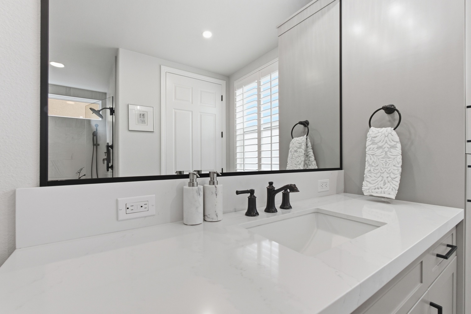 Close up of Fresno CA bathroom vanity with white countertop and black fixtures Close up of Fresno CA bathroom vanity with white countertop and black fixtures