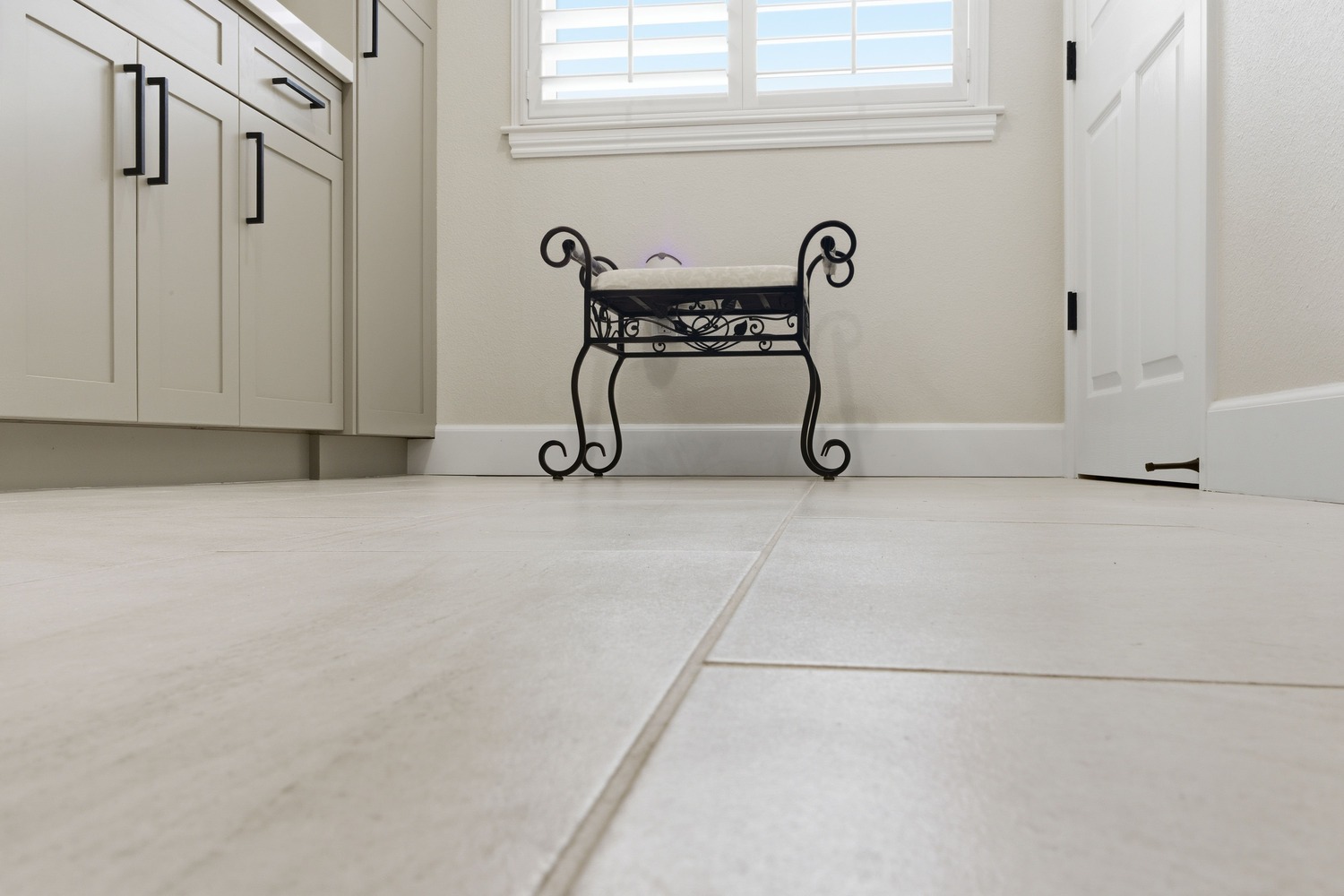 Close-up of tiled bathroom floor and bench with decorative stool in a Fresno home Close-up of tiled bathroom floor and bench with decorative stool in a Fresno home
