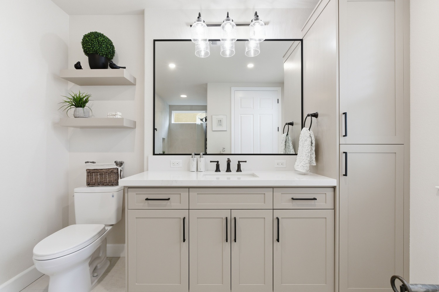 Remodeled Fresno CA bathroom featuring taupe cabinets, open shelves, and a wide vanity mirror Remodeled Fresno CA bathroom featuring taupe cabinets, open shelves, and a wide vanity mirror