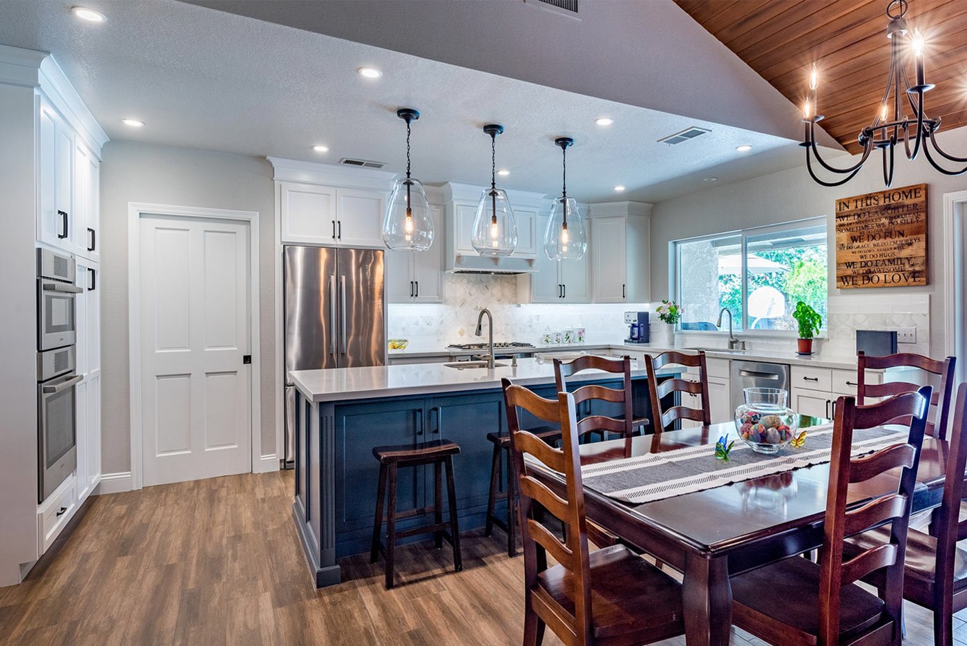 Modern kitchen with white cabinetry, navy island, and wood floors in Fresno, CA
