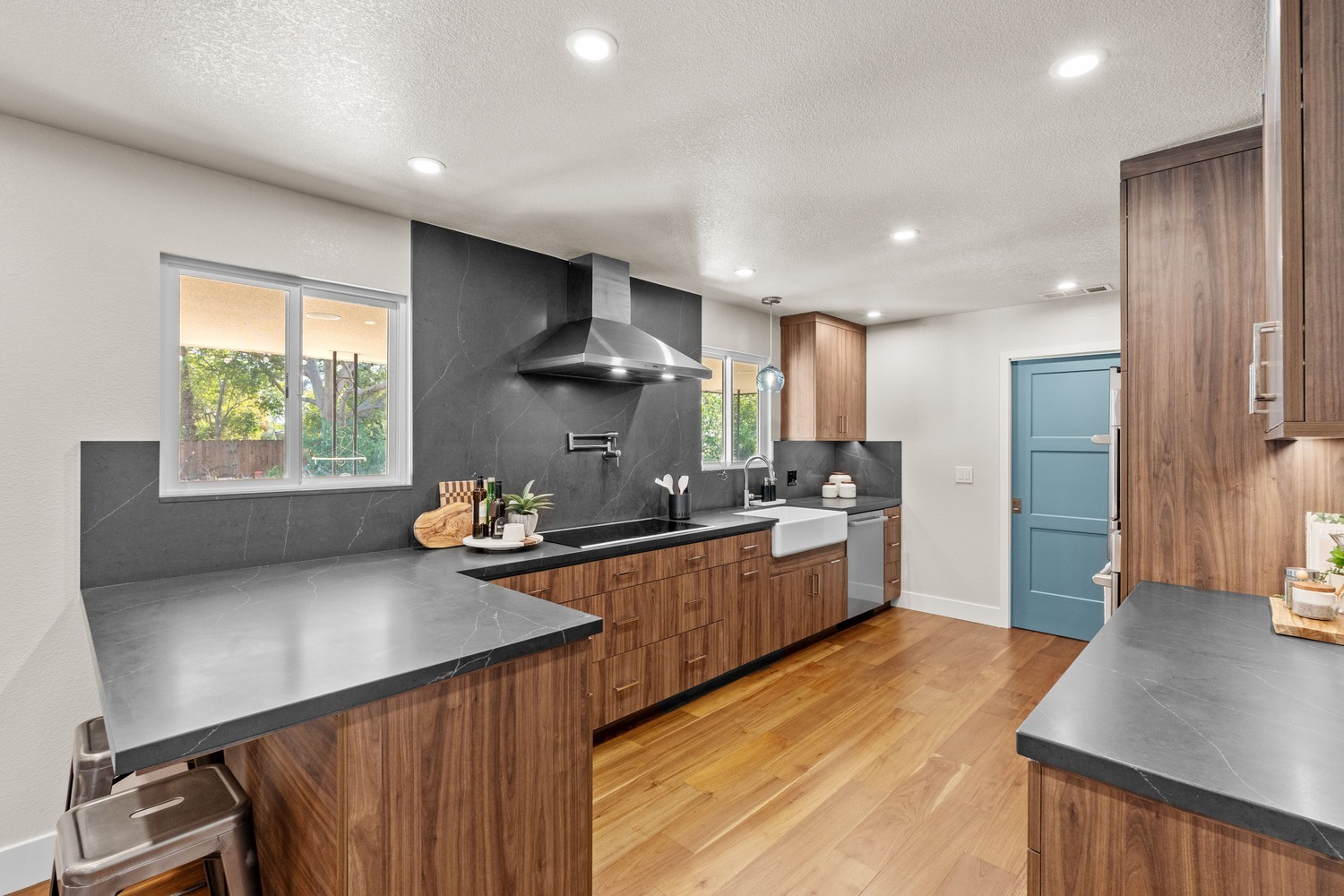 Modern Fresno kitchen with dark stone backsplash, wood cabinets, and blue door