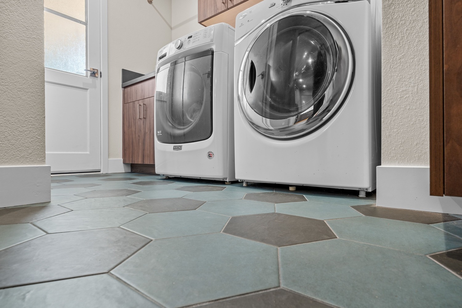 Modern laundry room in Fresno with hexagon tile flooring and front load washer and dryer Modern laundry room in Fresno with hexagon tile flooring and front load washer and dryer