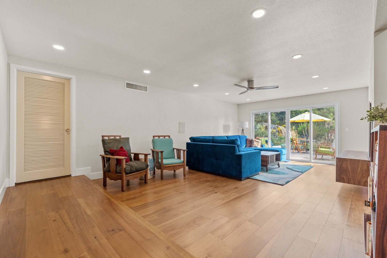 Spacious Fresno living area with wood floors, blue sectional, and large sliding glass doors