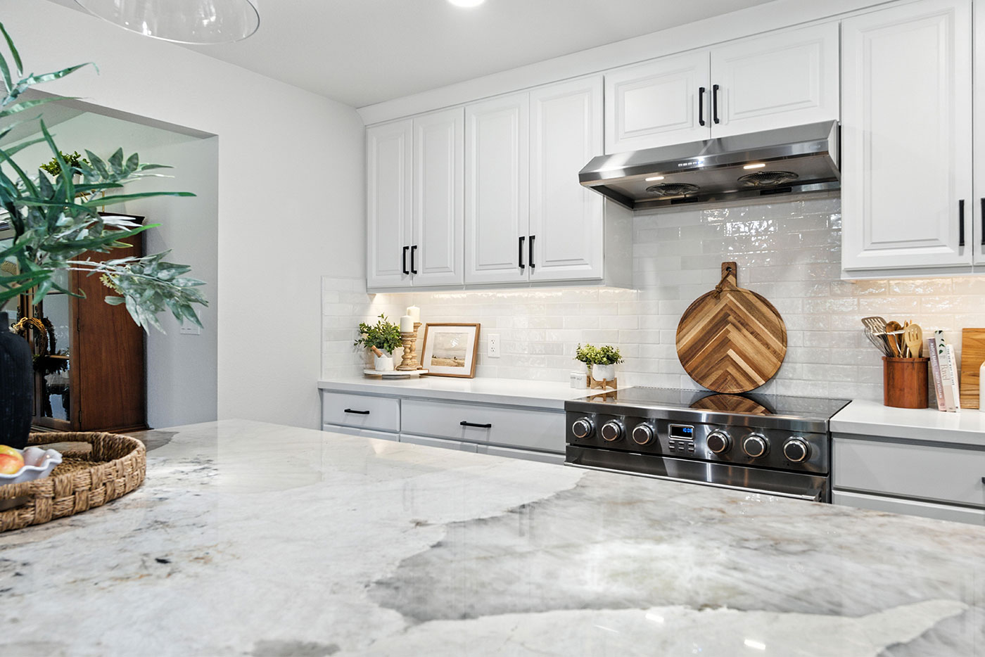Elegant Clovis, CA kitchen with white cabinetry, stainless steel range, and bright marble counters Elegant Clovis, CA kitchen with white cabinetry, stainless steel range, and bright marble counters