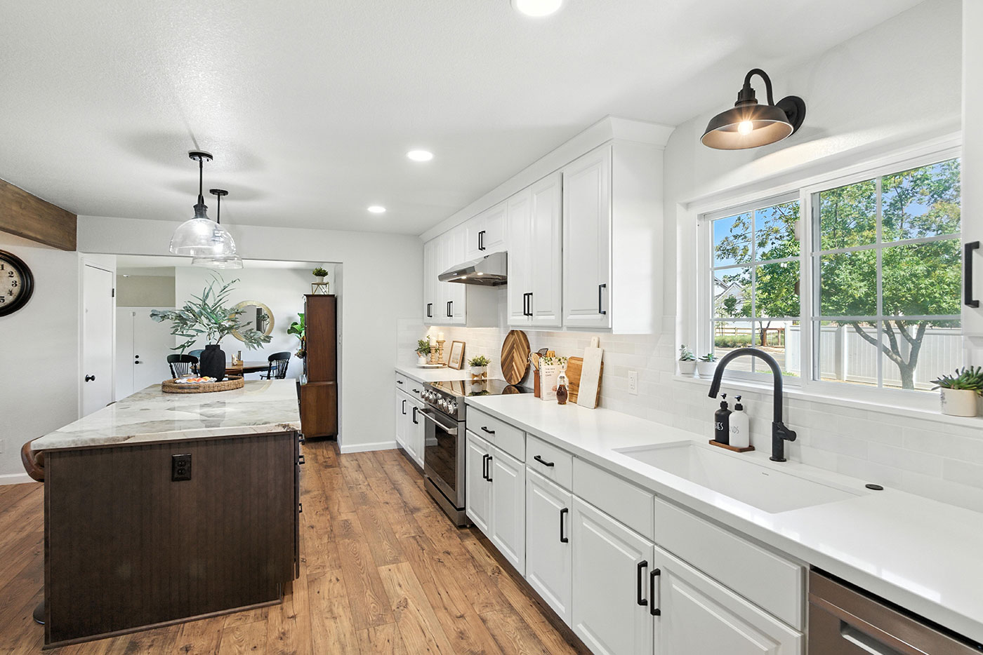 Modern kitchen with white cabinets, large island, and wood flooring in a home in Clovis, C Modern kitchen with white cabinets, large island, and wood flooring in a home in Clovis, C