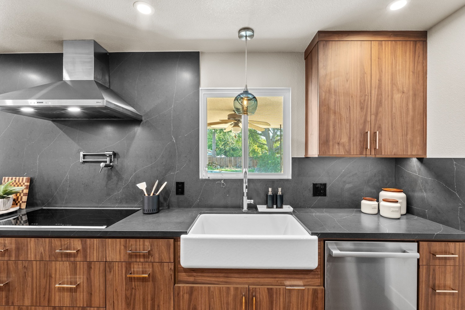 Fresno kitchen with large farmhouse sink, wood cabinetry, and blue glass pendant light