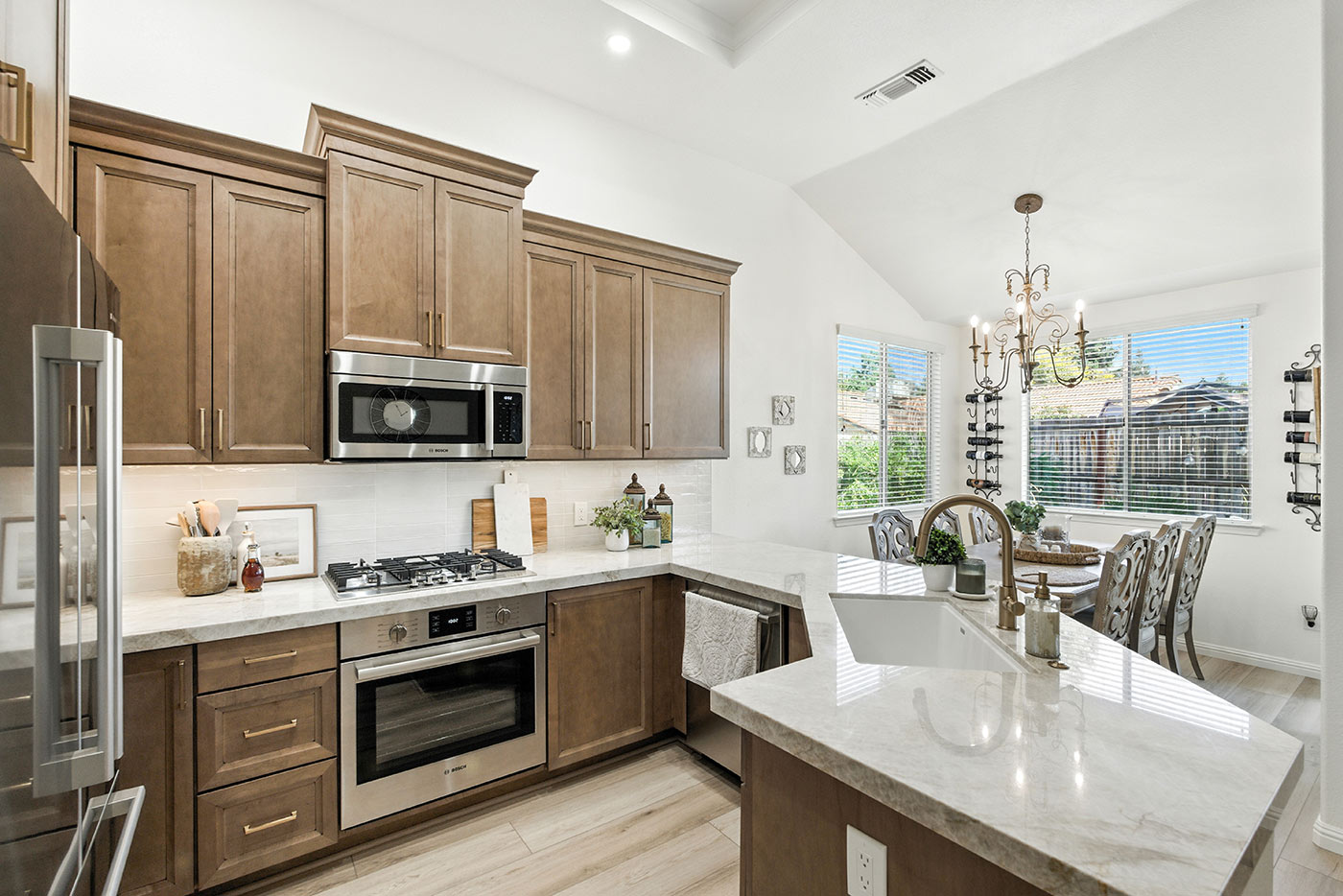 Bright Fresno kitchen with wood cabinetry, marble countertops, and a cozy dining nook