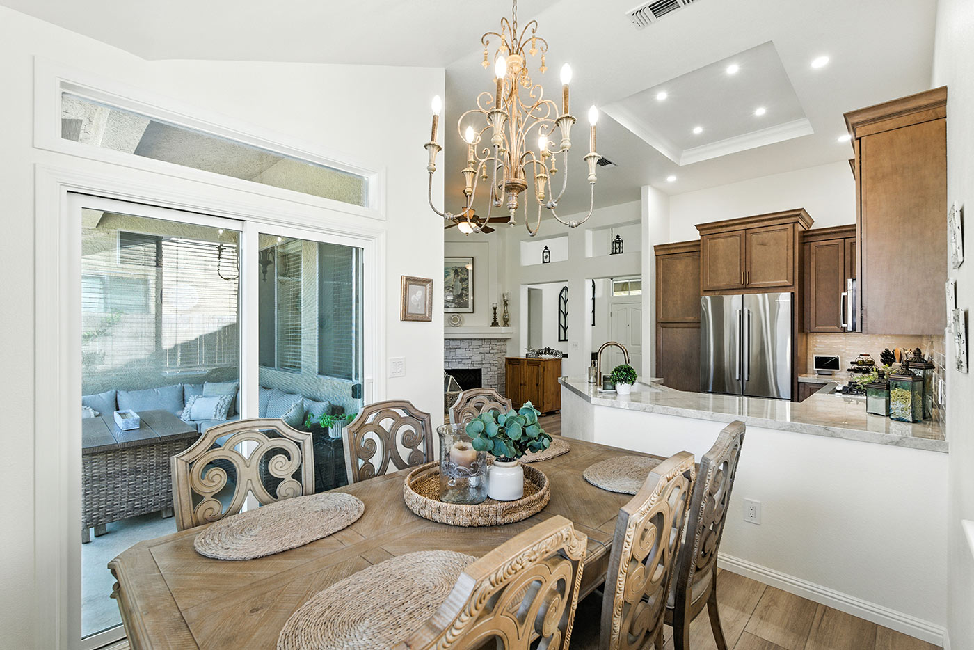 Fresno dining and kitchen area remodeled by Imagine Remodeling featuring ornate chandelier and open layout