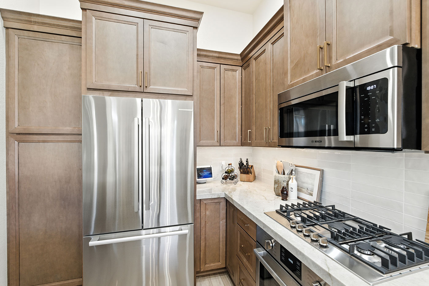 Modern kitchen with wood cabinets, marble countertops, and stainless appliances in Fresno, CA